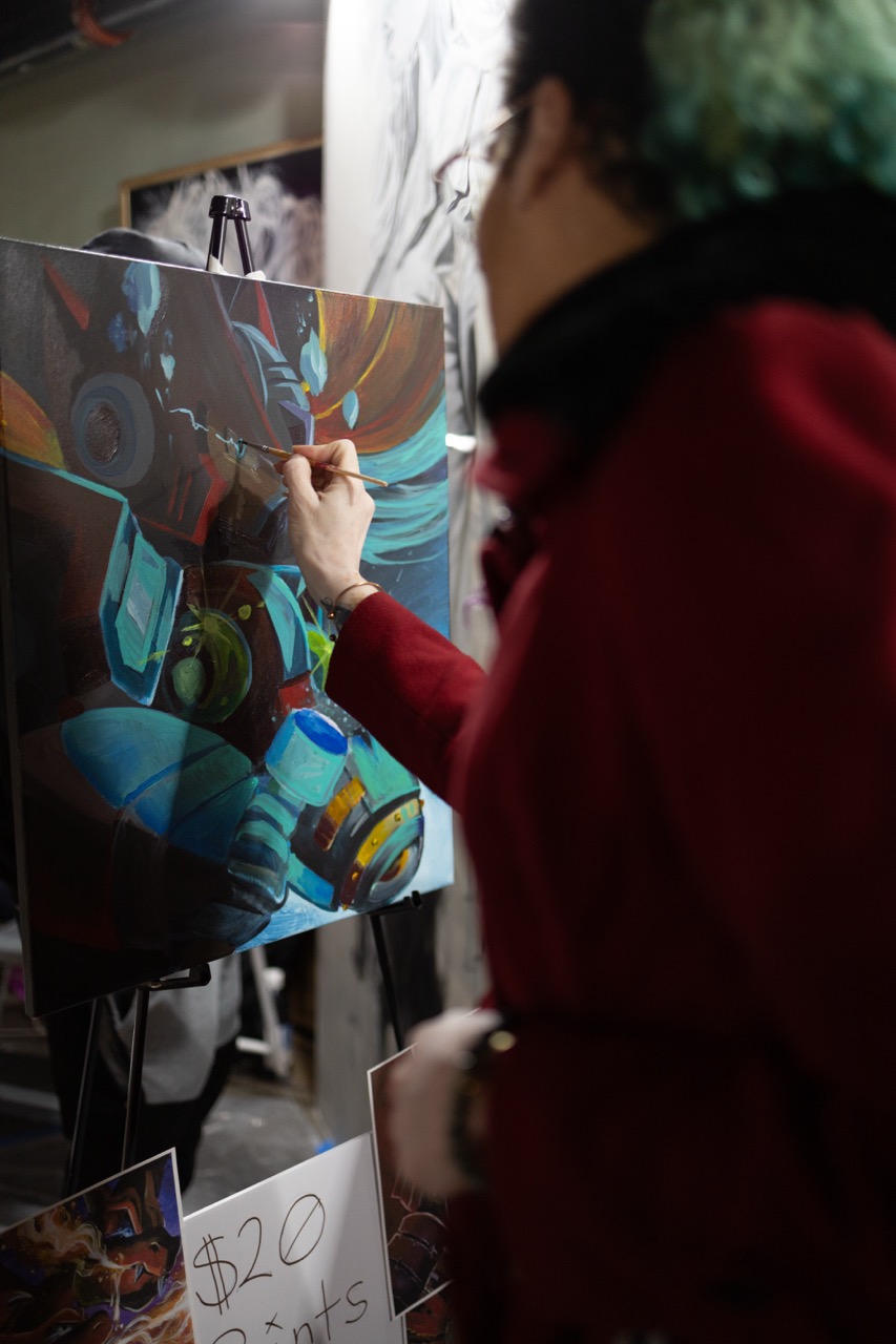 Live painter mid-stroke at Pancakes & Booze