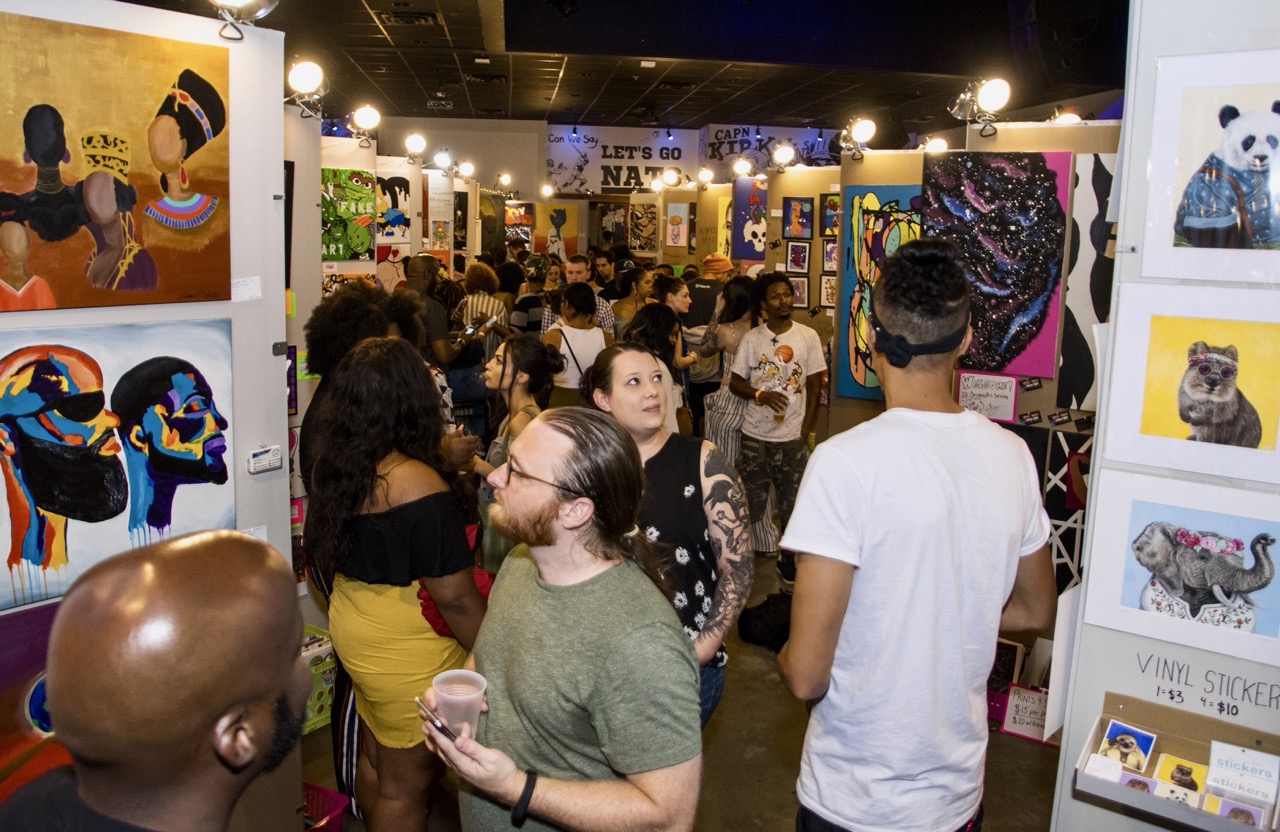 Crowd browsing the salon-style art walls