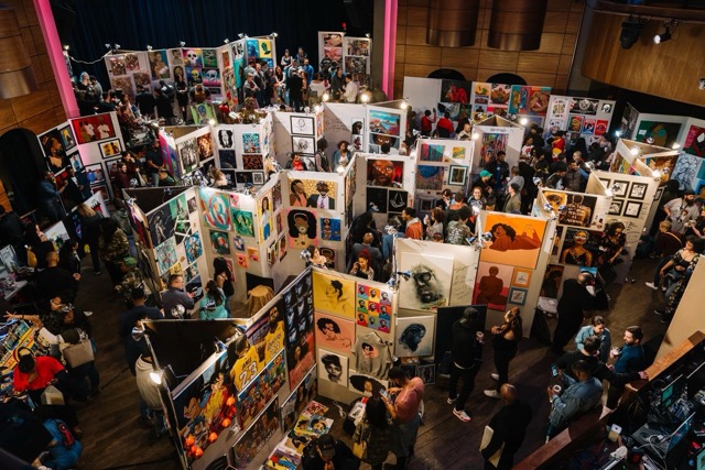 Overhead view of the Pancakes & Booze show floor packed with salon-style art walls and crowd